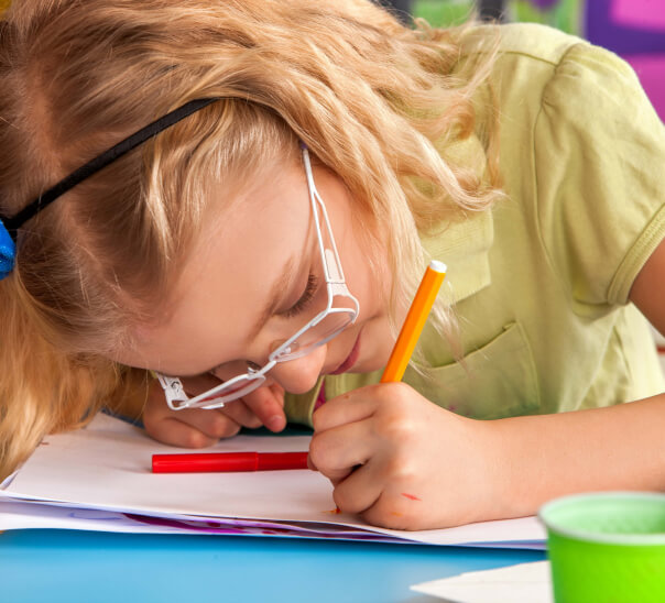 Girl wearing glasses while writing