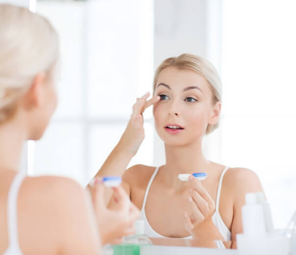 Woman putting on contact lens