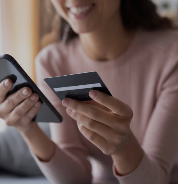 Woman using a smartphone and credit card for online payment