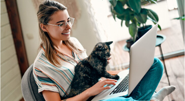 Woman with her cat using laptop